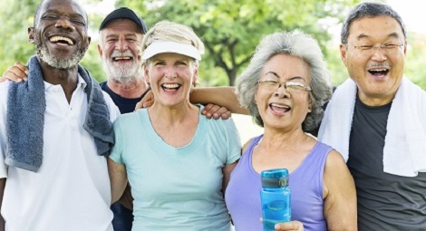 Group of older people in a park with towels and drinks after exercise